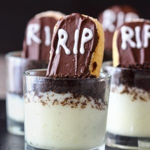 Mini RIP Halloween dessert shooter layered with vanilla pudding, Oreo crumbs and a chocolate-covered ladyfinger gravestone.