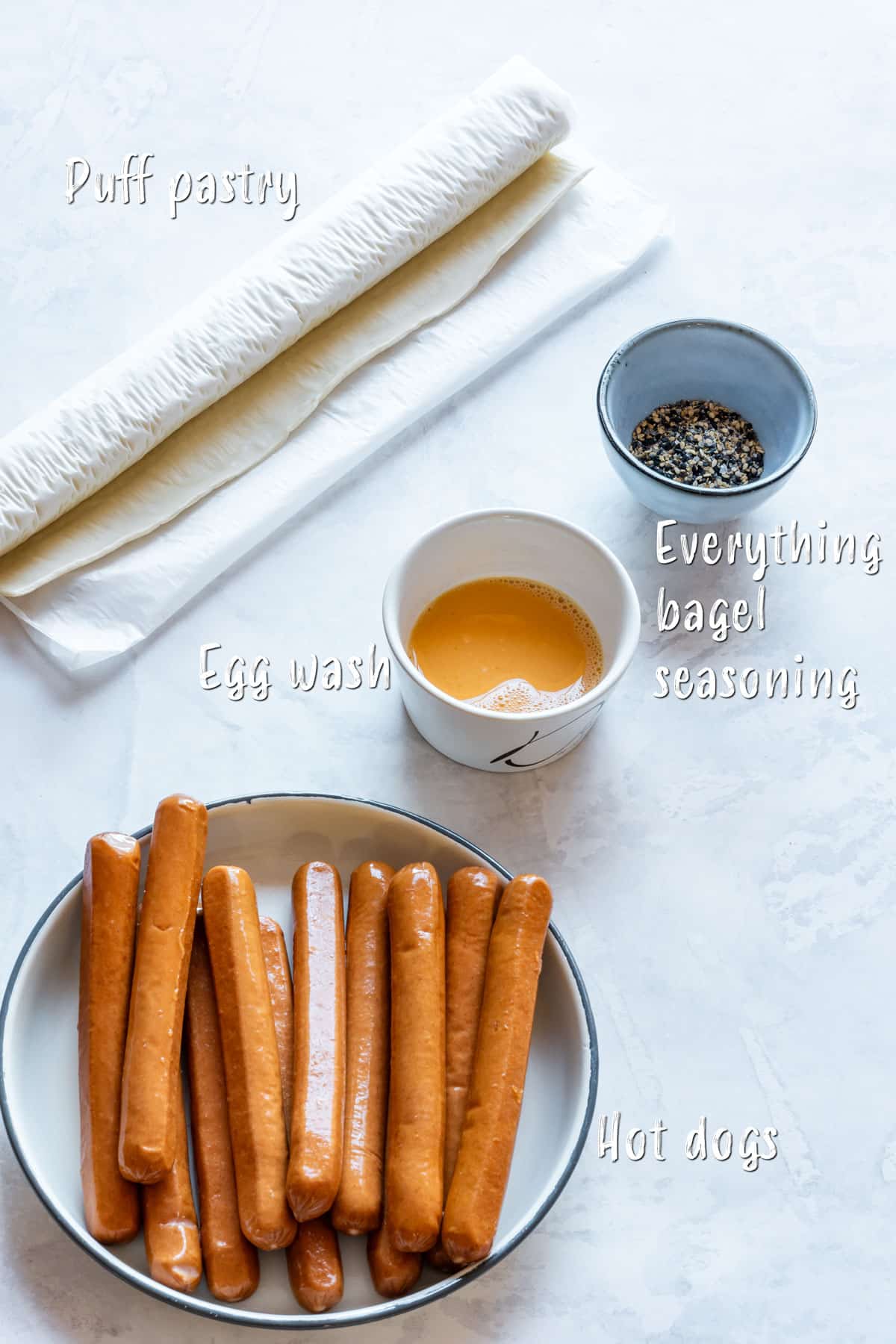 Ingredients for a recipe: puff pastry, hot dogs, egg wash and everything bagel seasoning.