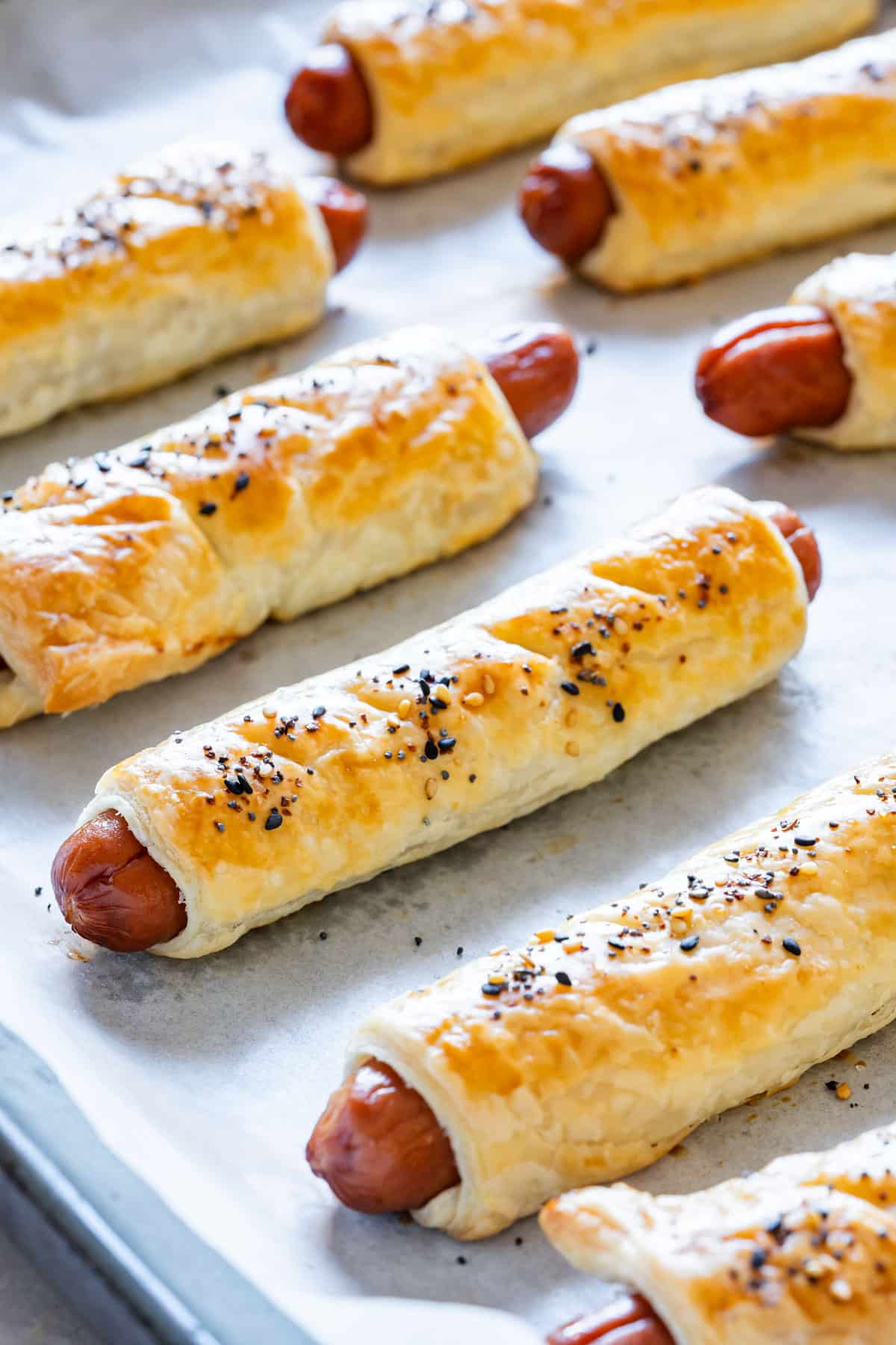 Homemade puff pastry wrapped hot dogs, sprinkled with everyday bagel seasoning.