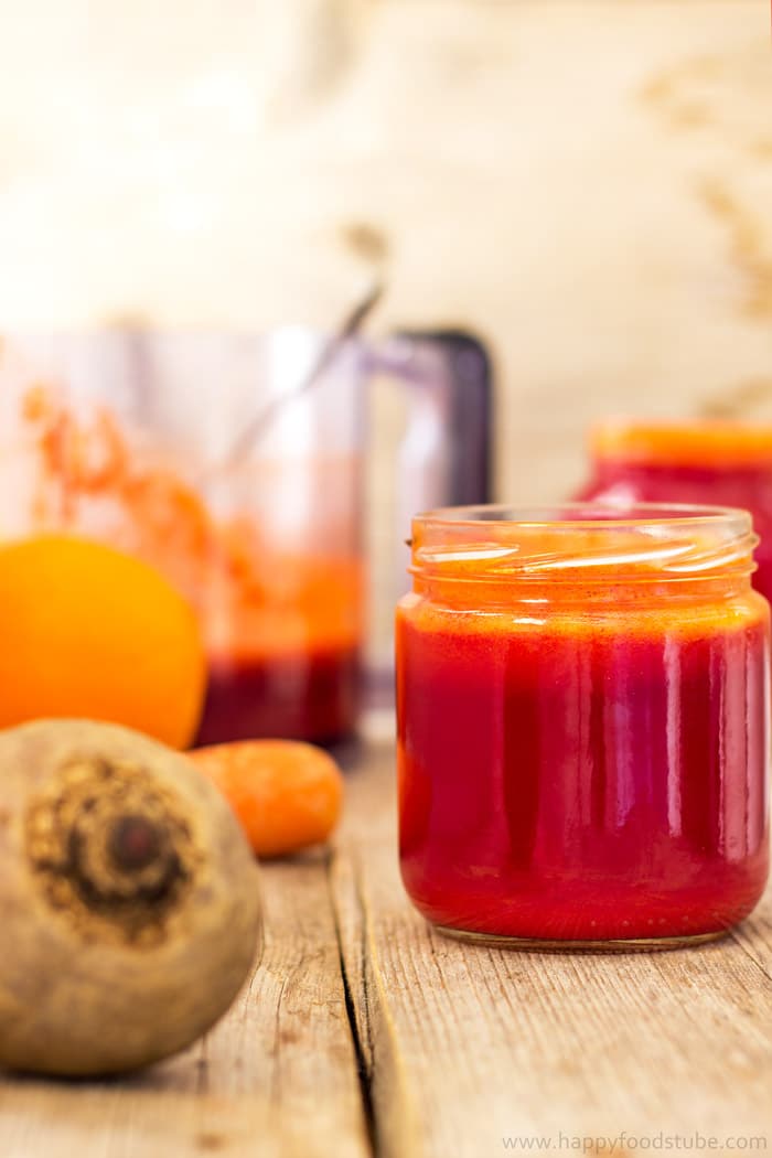 Jar of beet, carrot and orange juice with fresh produce.