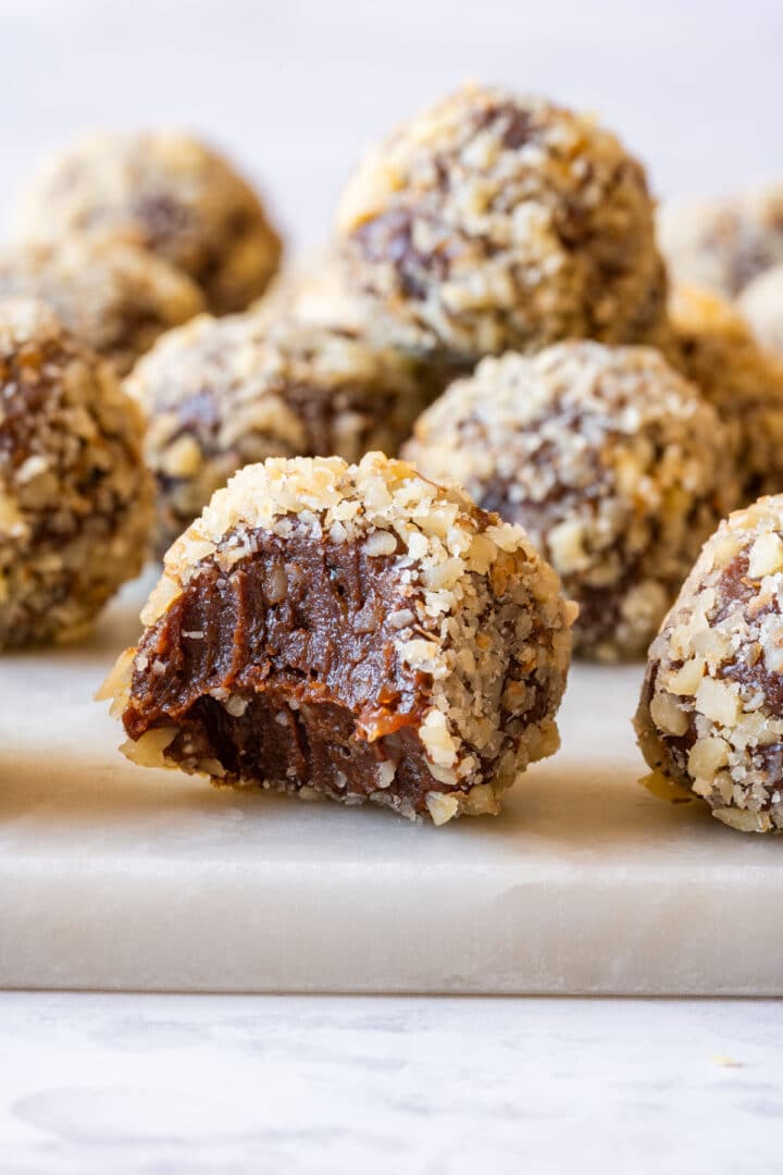 Bitten chocolate walnut truffle showing a rich, fudgy center.