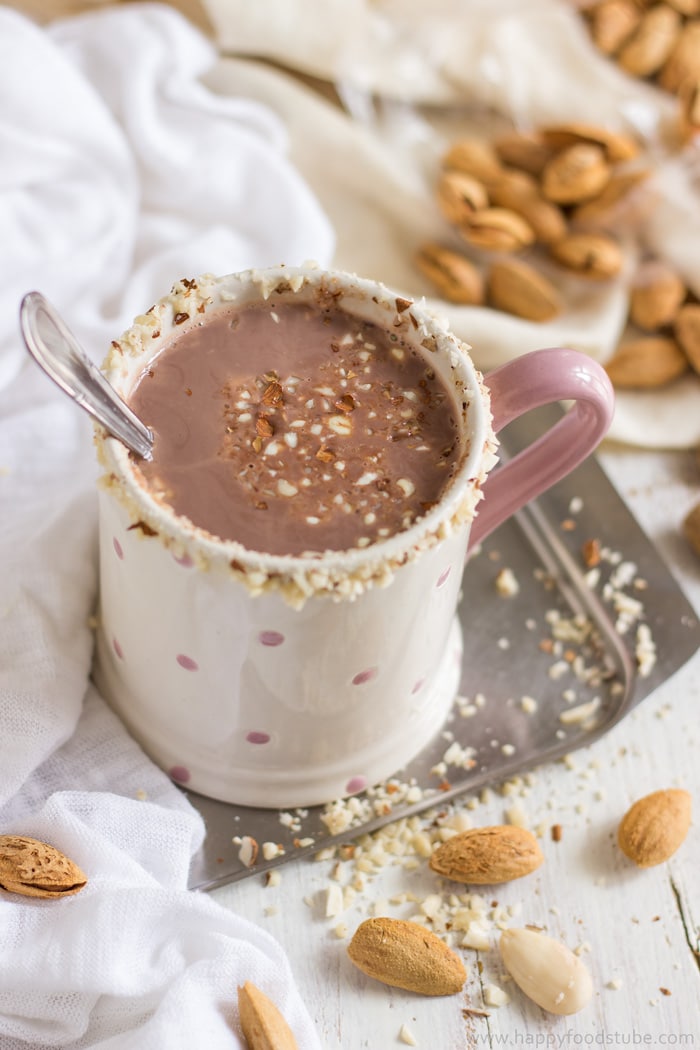 Mug of healthy hot cocoa with almond milk topped with almonds