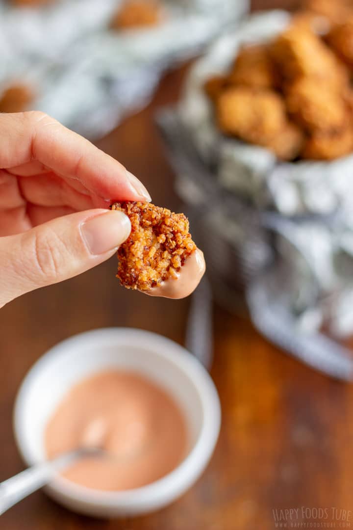 Dipping popcorn chicken piece to the sauce
