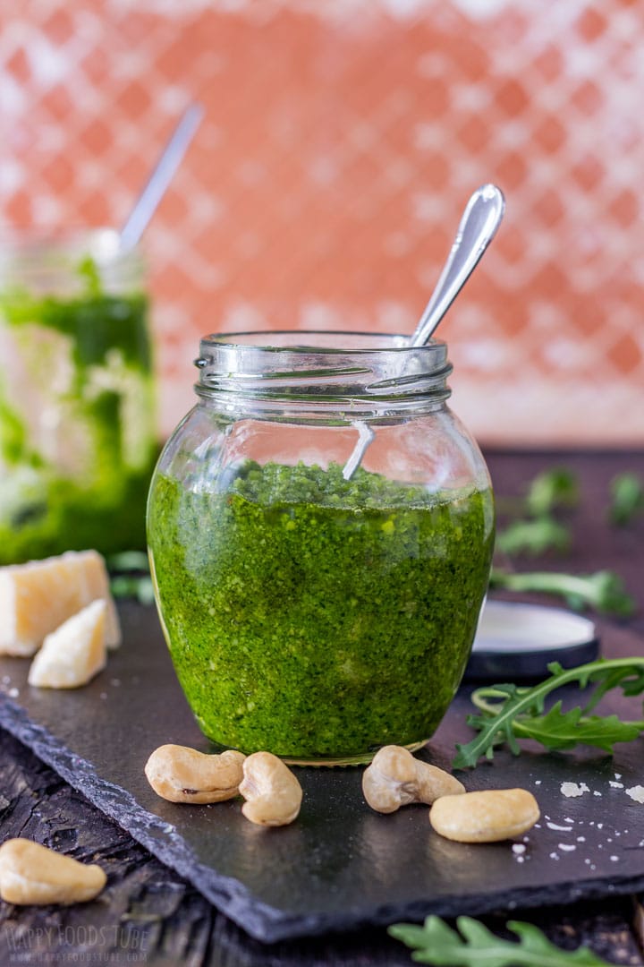 Green arugula pesto in the jar with spoon