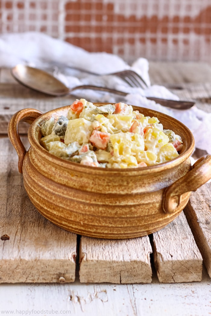 Bowl of homemade dill pickle potato salad on a rustic table.