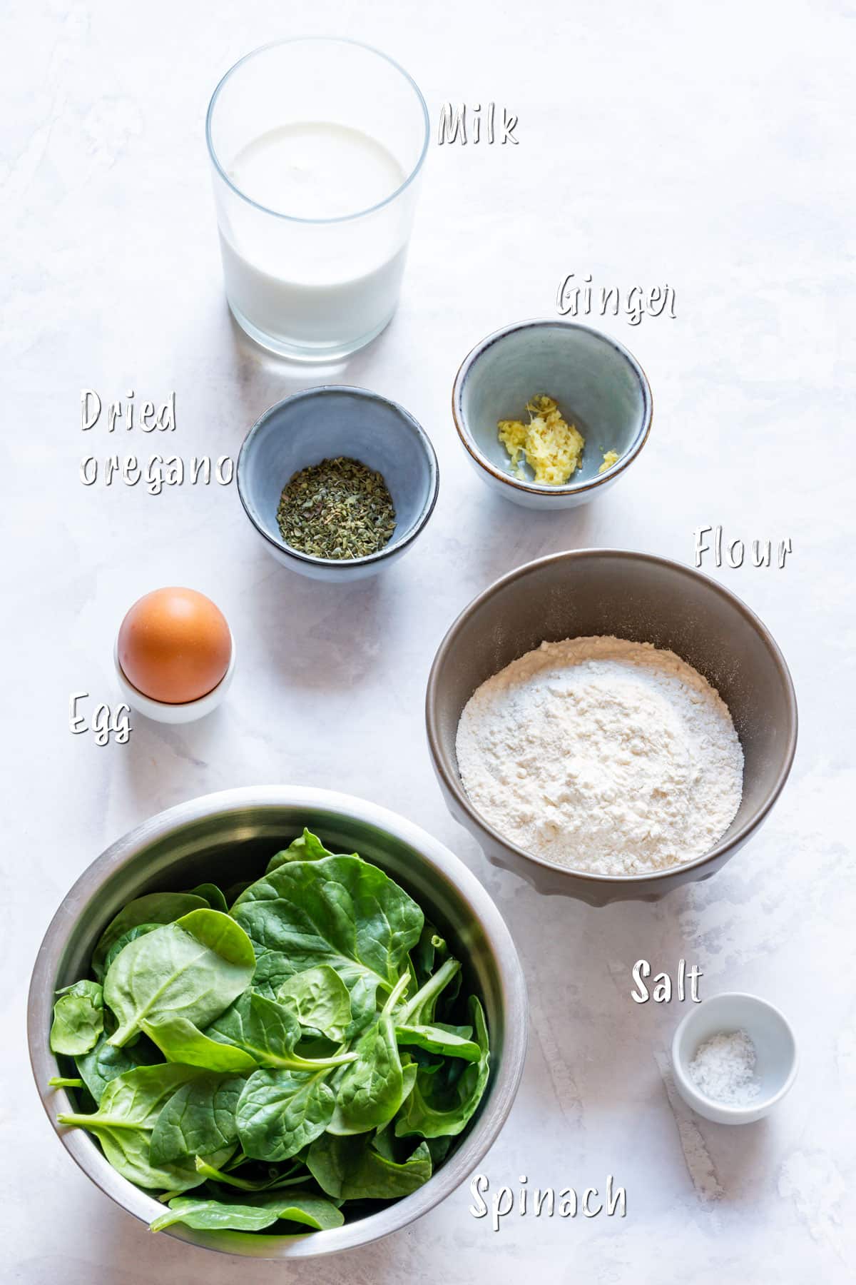 Ingredients for spinach crepe batter: milk, ginger, flour, salt, spinach, egg and dried oregano.