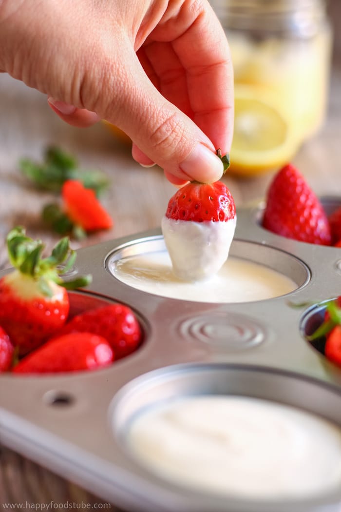 Strawberry covered with lemon curd dip.