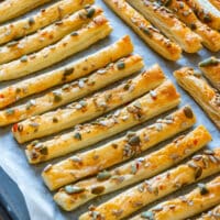 Homemade sweet chili puff pastry breadsticks topped with mixed seeds.