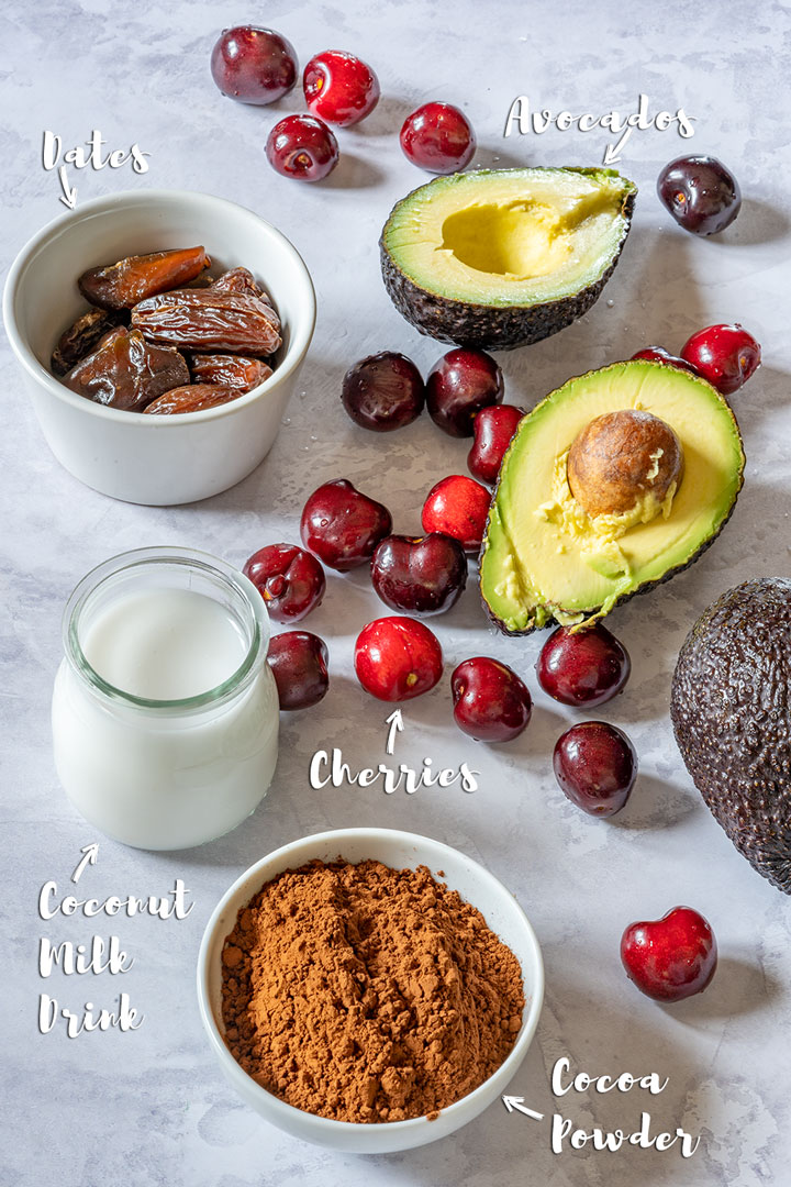 Vegan chocolate mousse ingredients - dates, avocados, coconut milk, cocoa powder and cherries