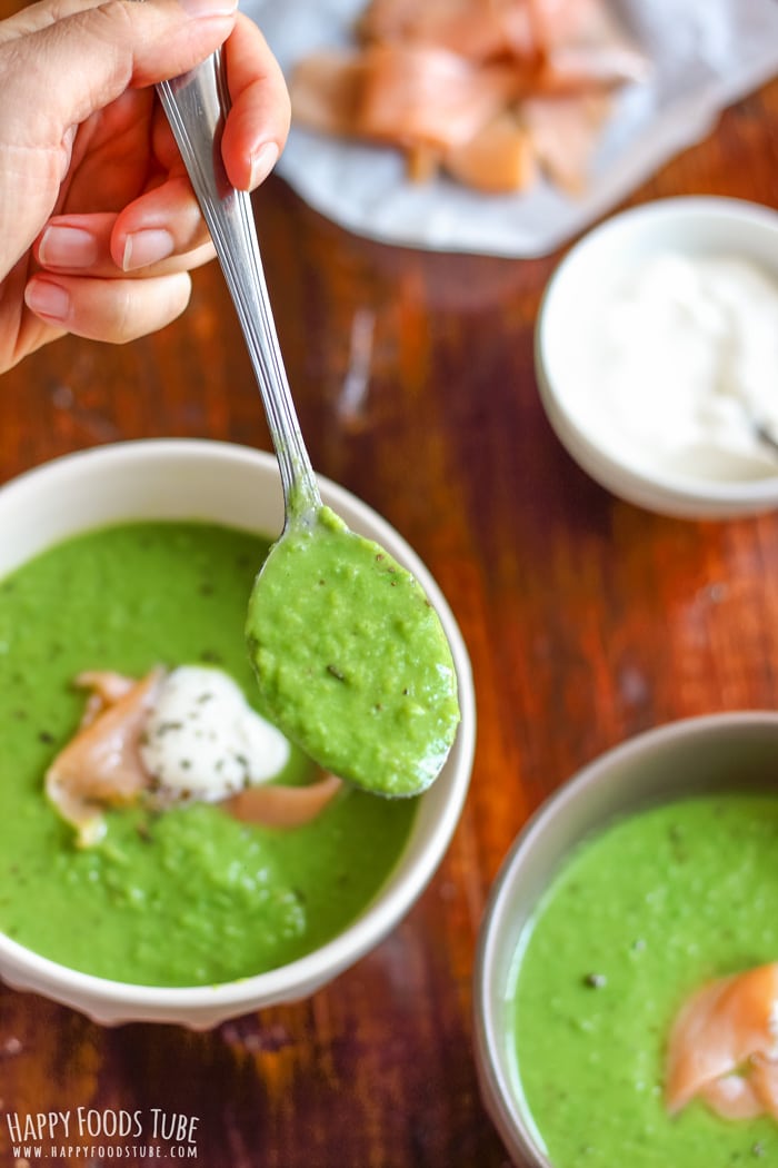 Spooning green pea soup from the bowl