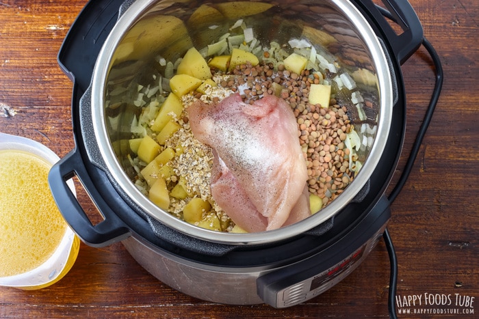 Chicken, lentils, potatoes, oats, onions in the Instant Pot, homemade chicken stock next to the Instant Pot