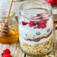 A jar of chocolate chip overnight oats with layers of oats, chocolate chips and a drizzle of honey.