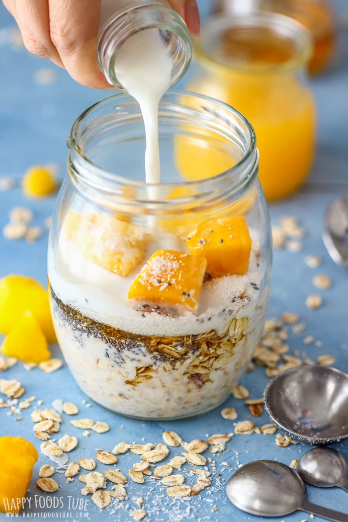 Pouring milk into Coconut Mango Overnight Oats