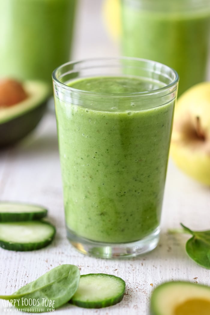 Green Spinach Cucumber Smoothie on the white table, fresh ingredients around