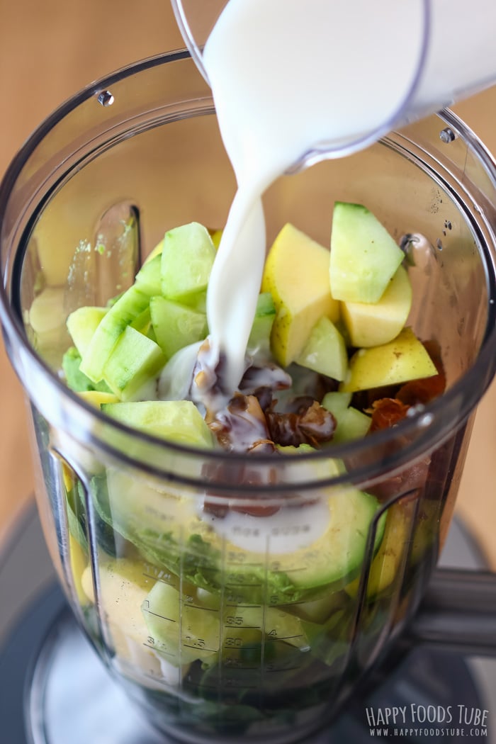 Pouring almond milk to the blender jug for Spinach Cucumber Smoothie