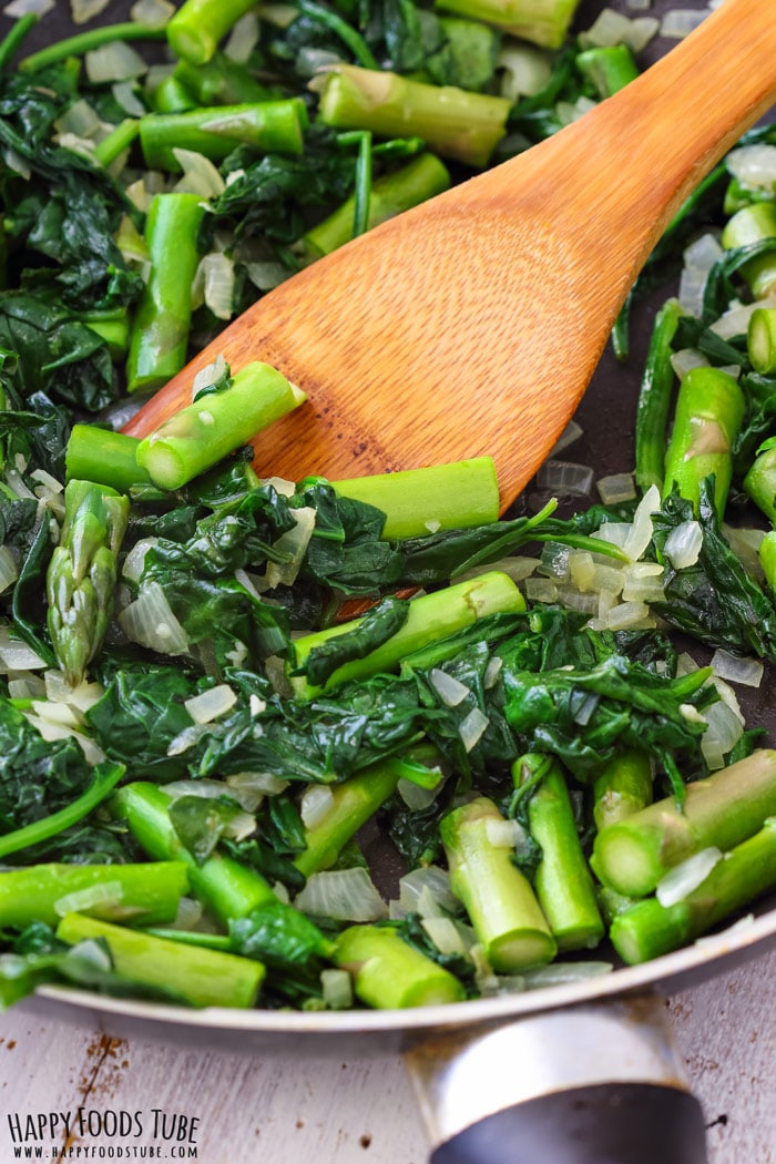 Cooking spinach and asparagus on the pan