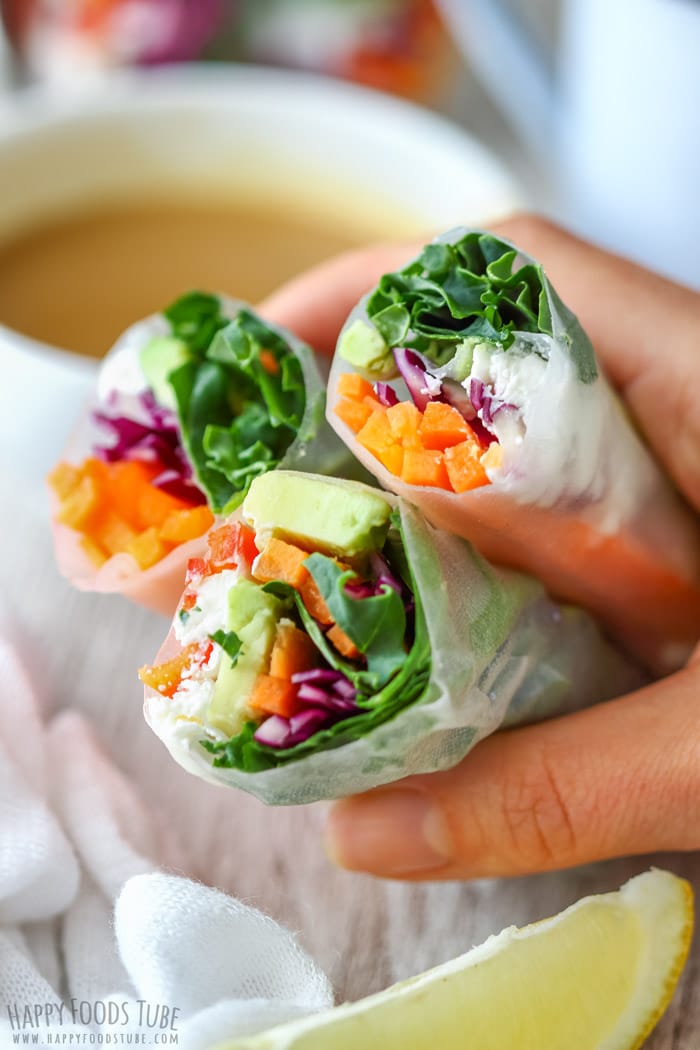 Three Vegetarian Fresh Spring Rolls with Peanut Sauce on the hand