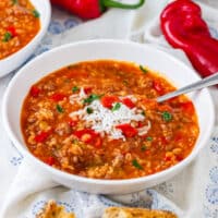 A bowl of hearty instant pot stuffed pepper soup garnished with herbs.