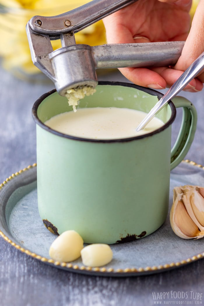 Crushing Garlic for Homemade Creamy Potatoes Au Gratin
