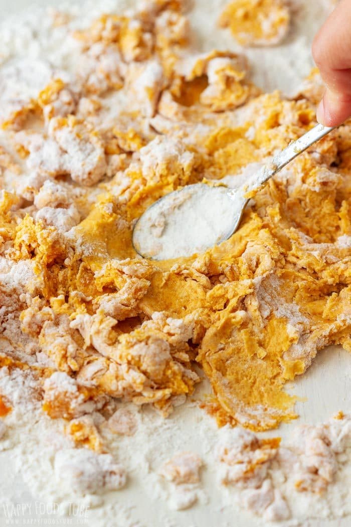 Mixing flour and pumpkin puree together to make dough.