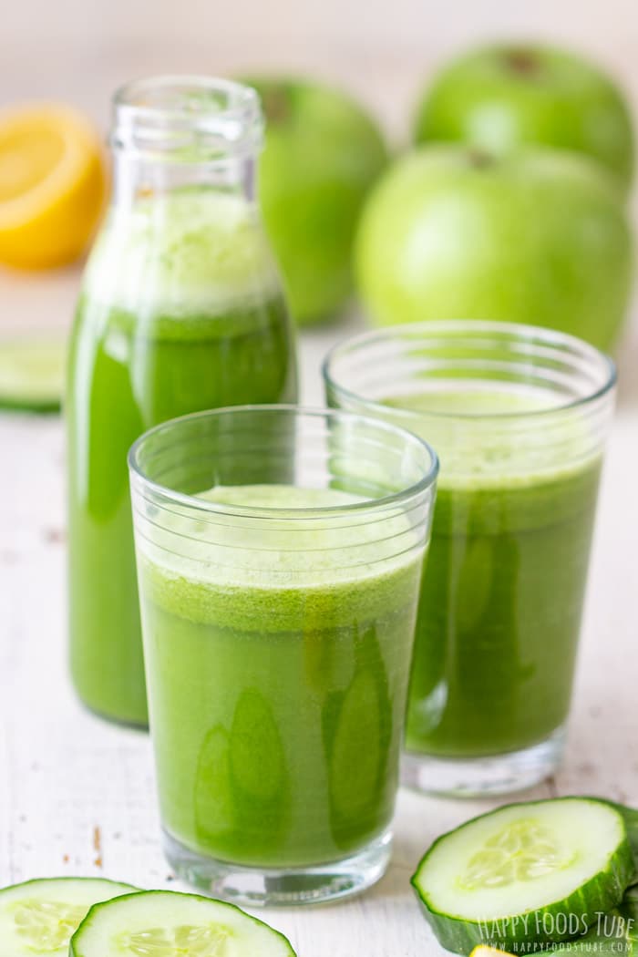 Bottle of fresh green juice and two glasses filled with juice.