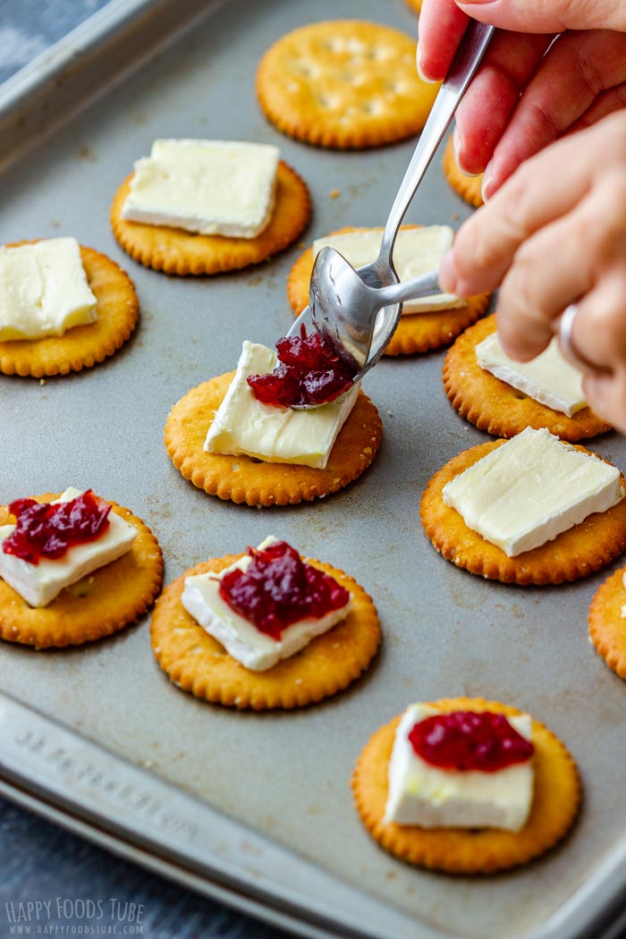 Showing how to add cranberry jam to brie.