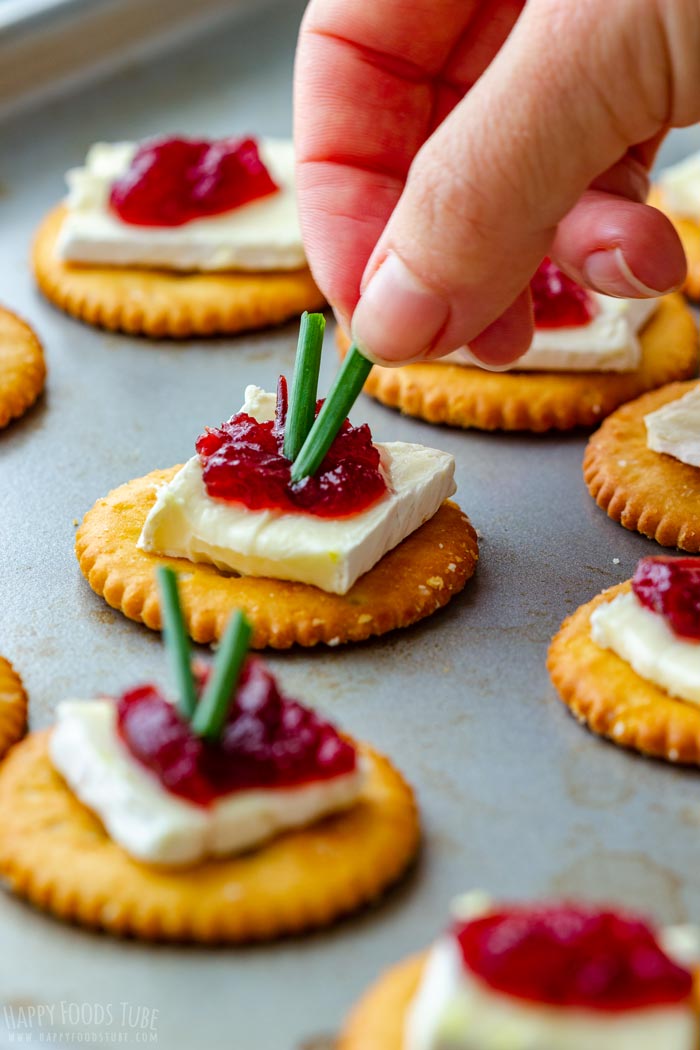 Topping the cranberry brie appetizers with chives.