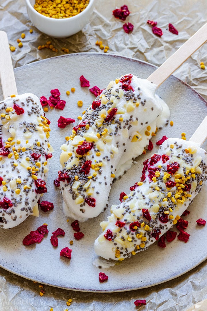 Frozen bananas covered with yogurt, raspberries, almonds and chia seeds