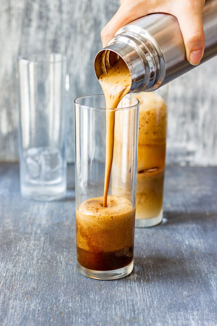 Pouring Greek frappe to the tall glass