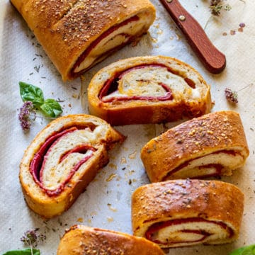 Close-up of sliced stromboli showing salami and mozzarella layers.