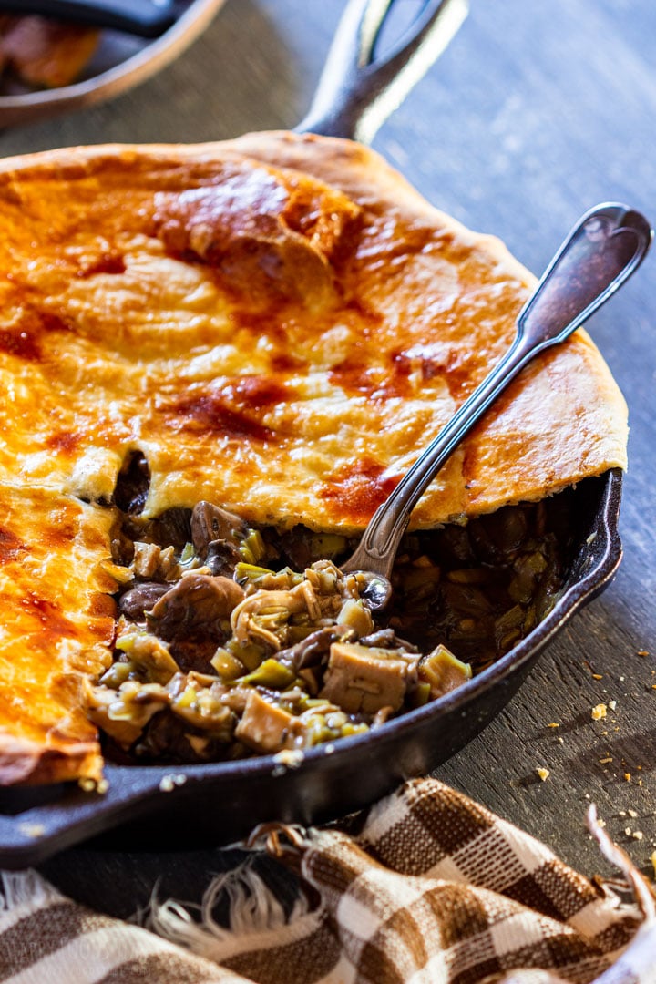 Comforting chicken and mushroom pie on a rustic table.
