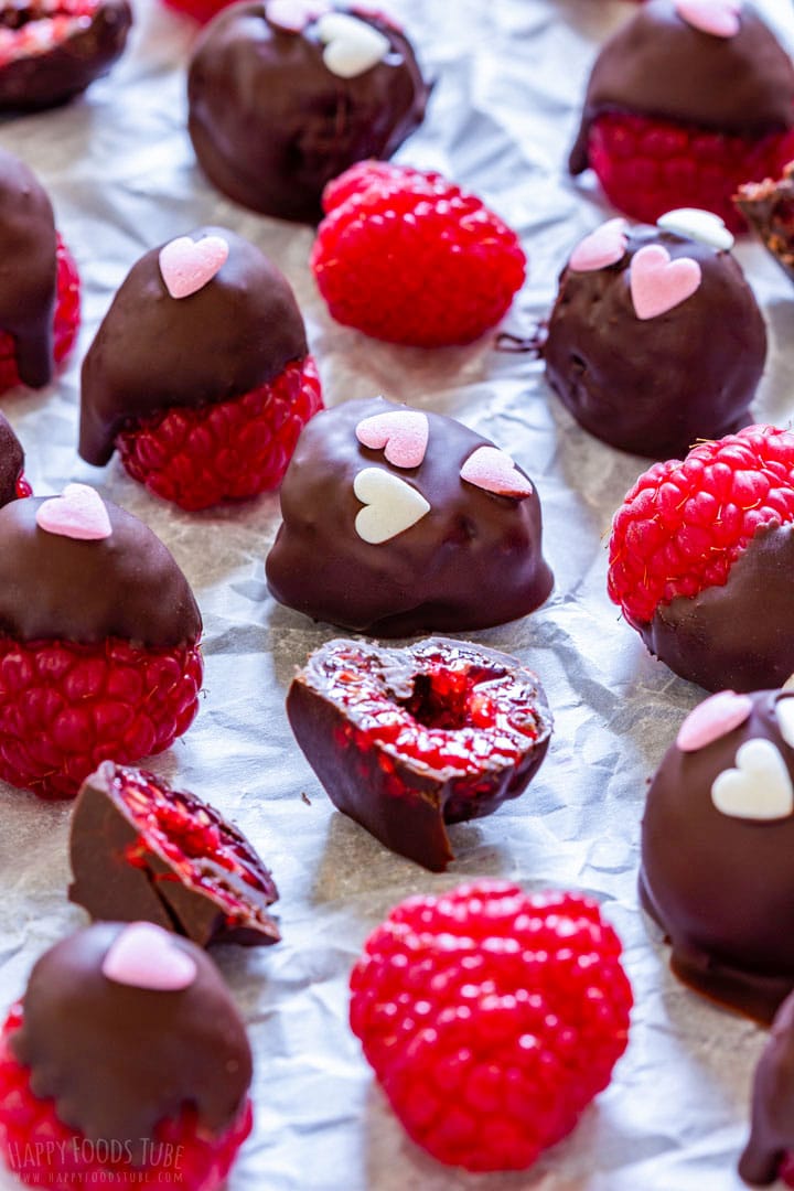 Chocolate covered raspberries with heart shaped sprinkles.