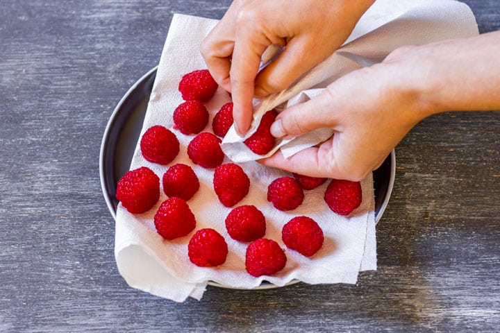 Preparing raspberries, getting rid of any water with kitchen towel.