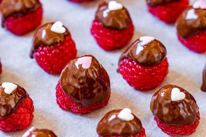 Top the chocolate raspberries with heart-shaped sprinkles.