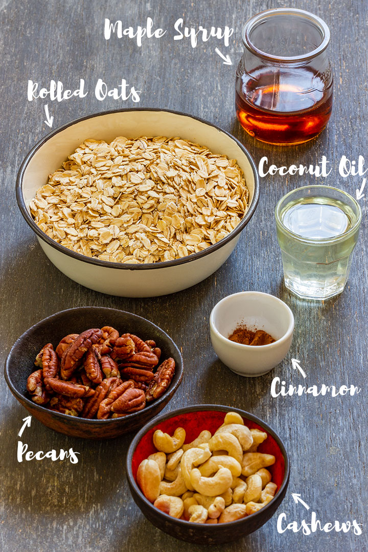 Rolled oats, pecans, cashews, cinnamon, coconut oil and maple syrup on the table