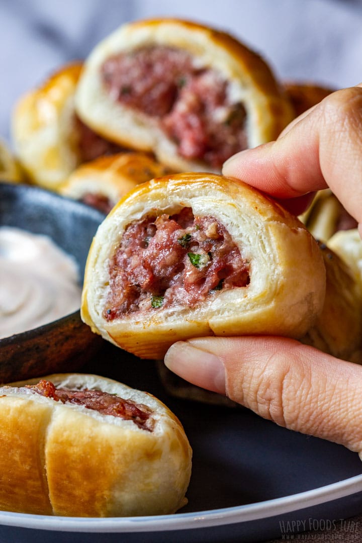 Dipping sausage roll to the sauce