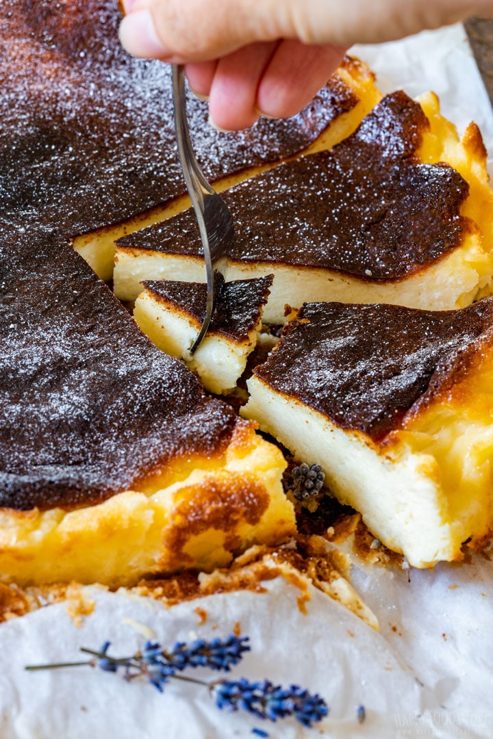 Taking bite of Basque cheesecake with fork