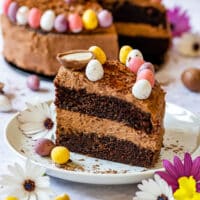Close-up of a chocolate Easter cake slice decorated with colorful candy eggs.
