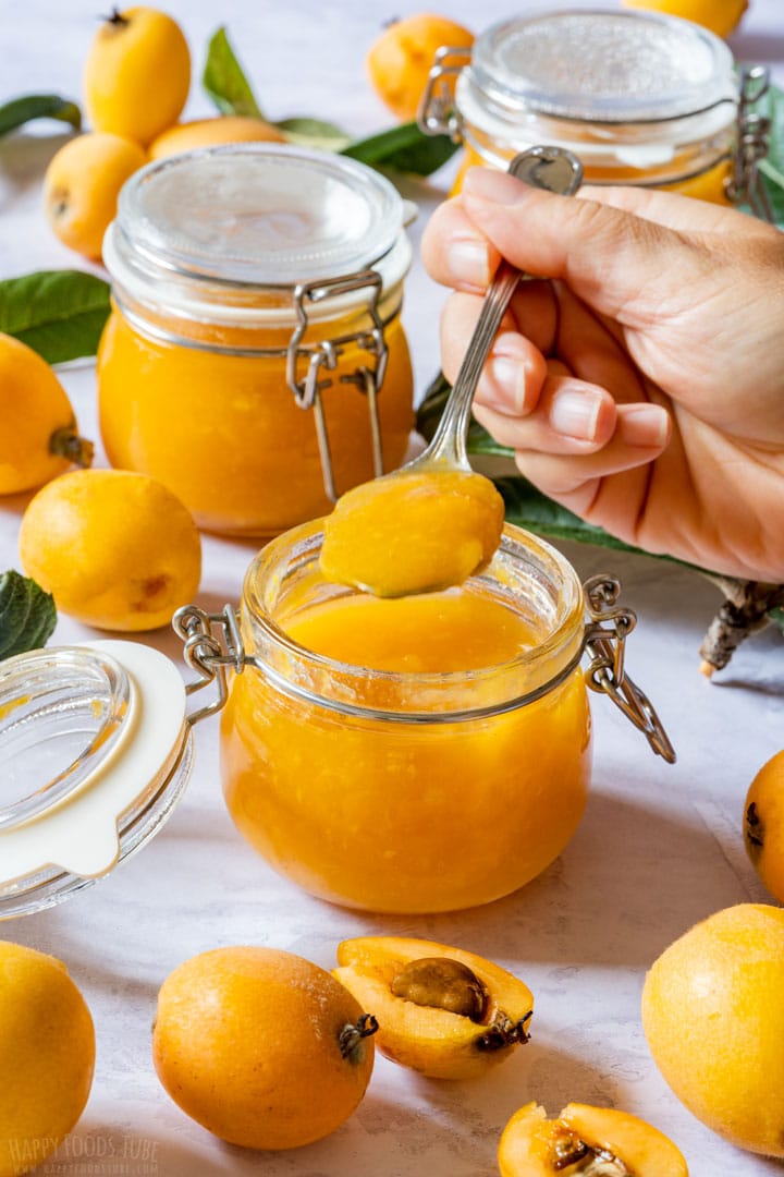 Spooning loquat jam from jar