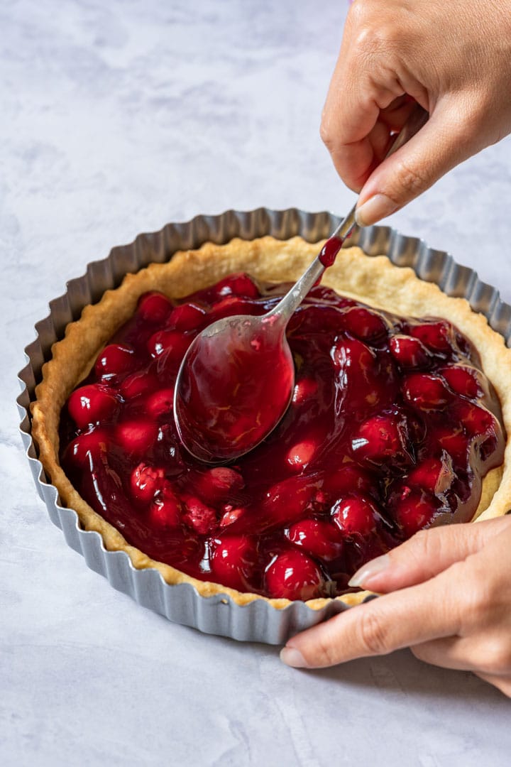 Filling the pie crust with cherry pie mix