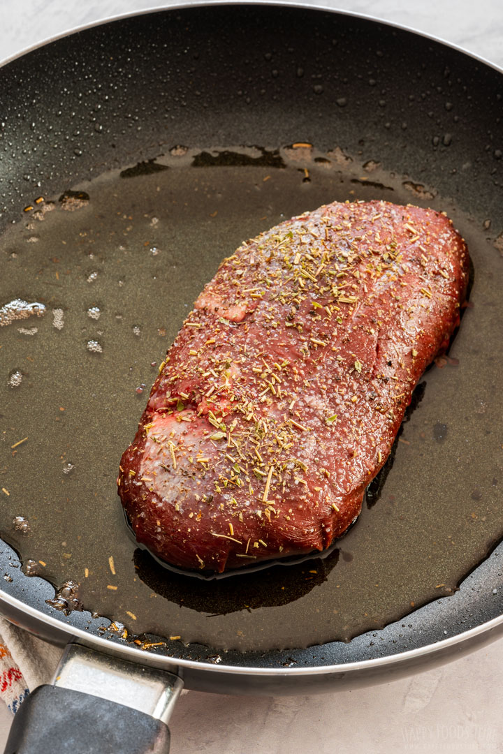 Browning seasoned duck breast on a skillet