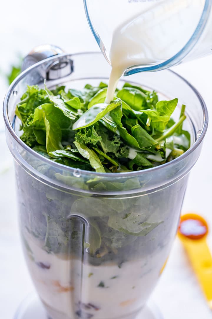 Pouring milk over smoothie ingredients