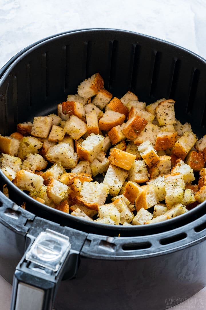 Air fryer tray filled with bread cubes to make croutons.
