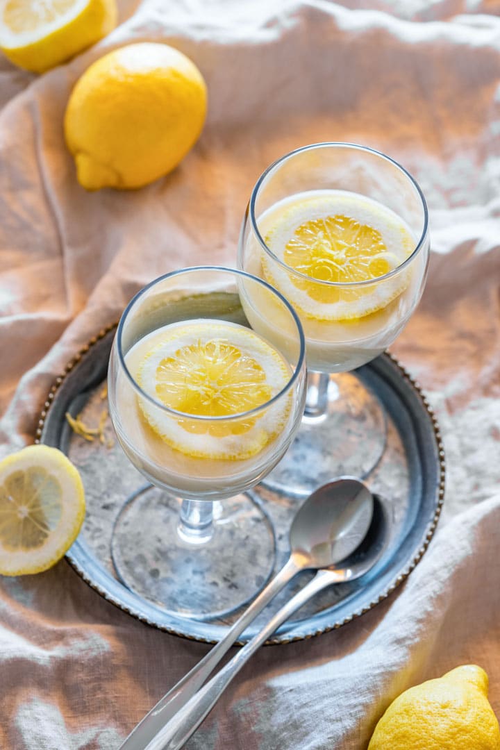 Lemon posset in a glass, decorated with slices of lemon.