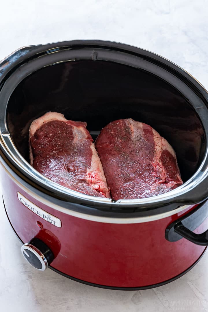 Uncooked duck breasts in the slow cooker.