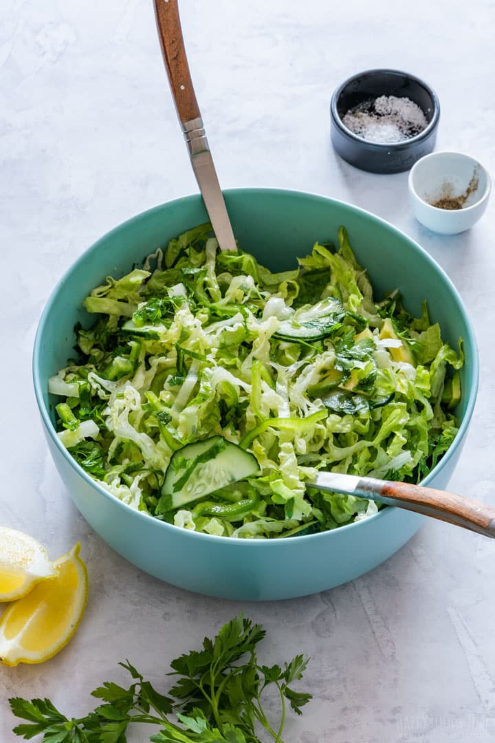 Bowl of Romaine lettuce salad with two spoons.