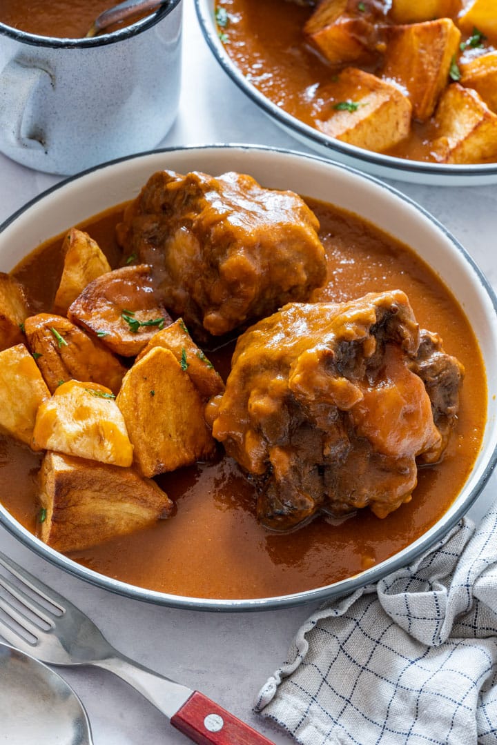 Spanish oxtail stew with with fried potatoes and rich sauce.