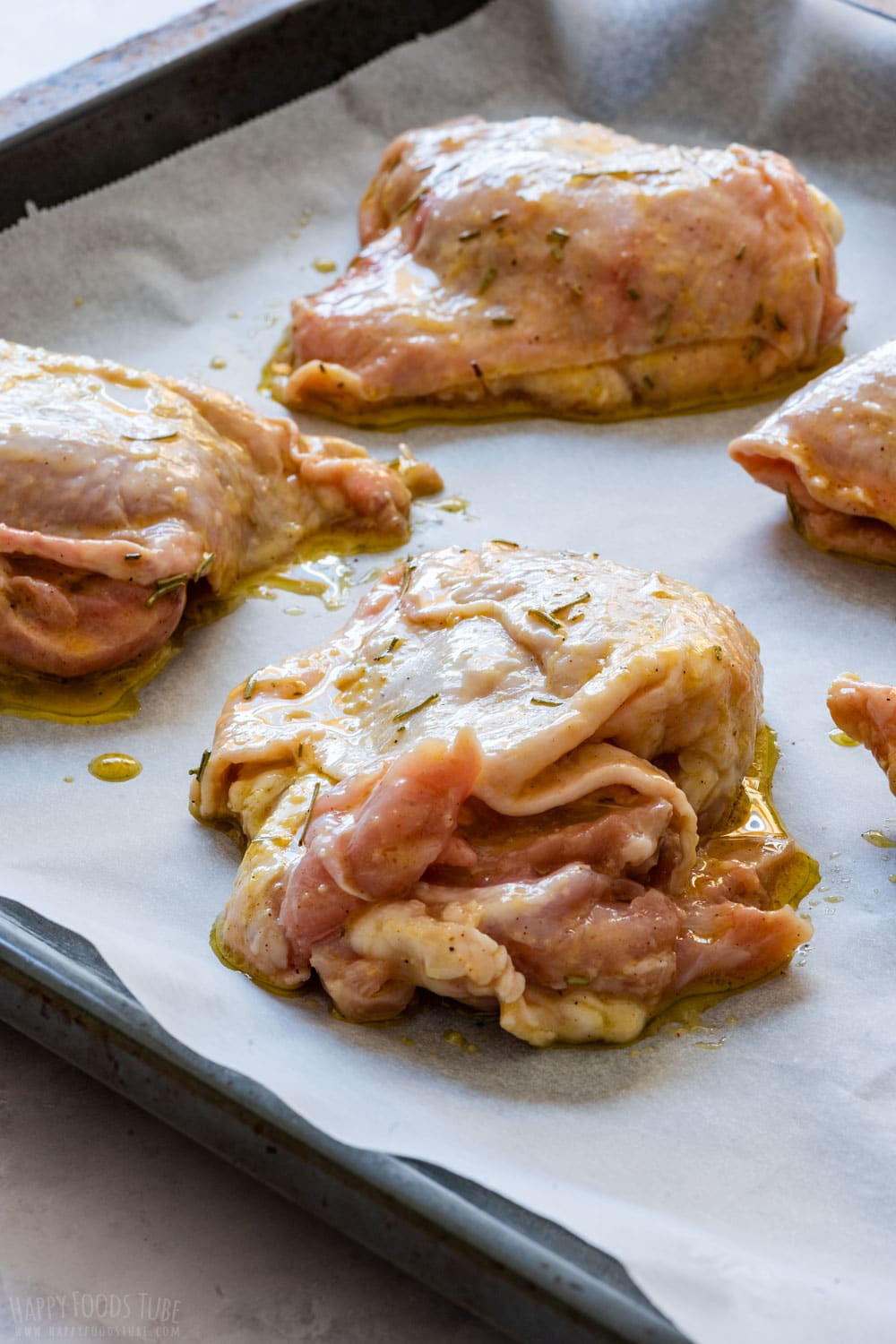 Raw beer marinated chicken thighs on the cooking tray.