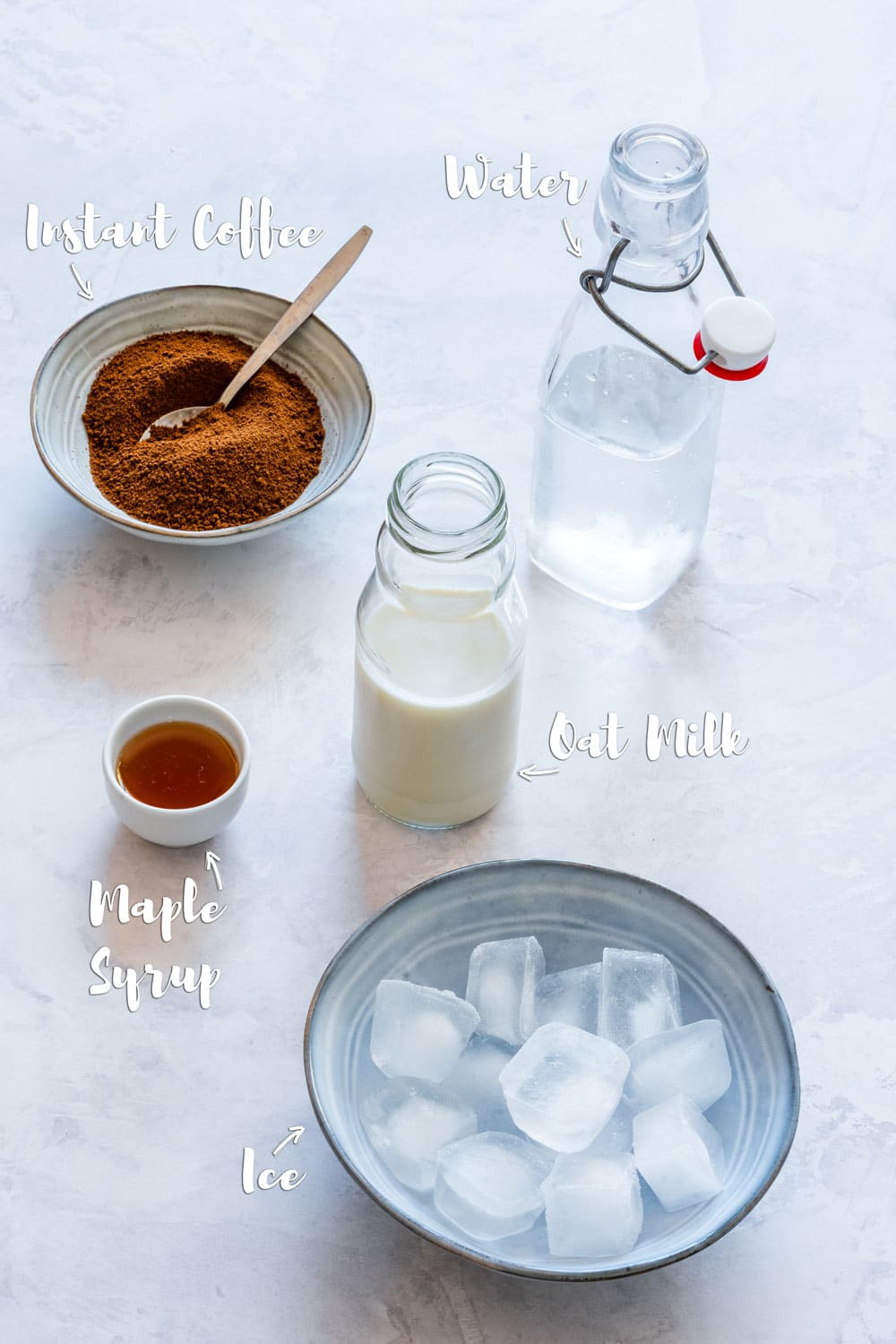 Ingredient for iced oat milk latte: instant coffee, oat milk, water, maple syrup and ice.