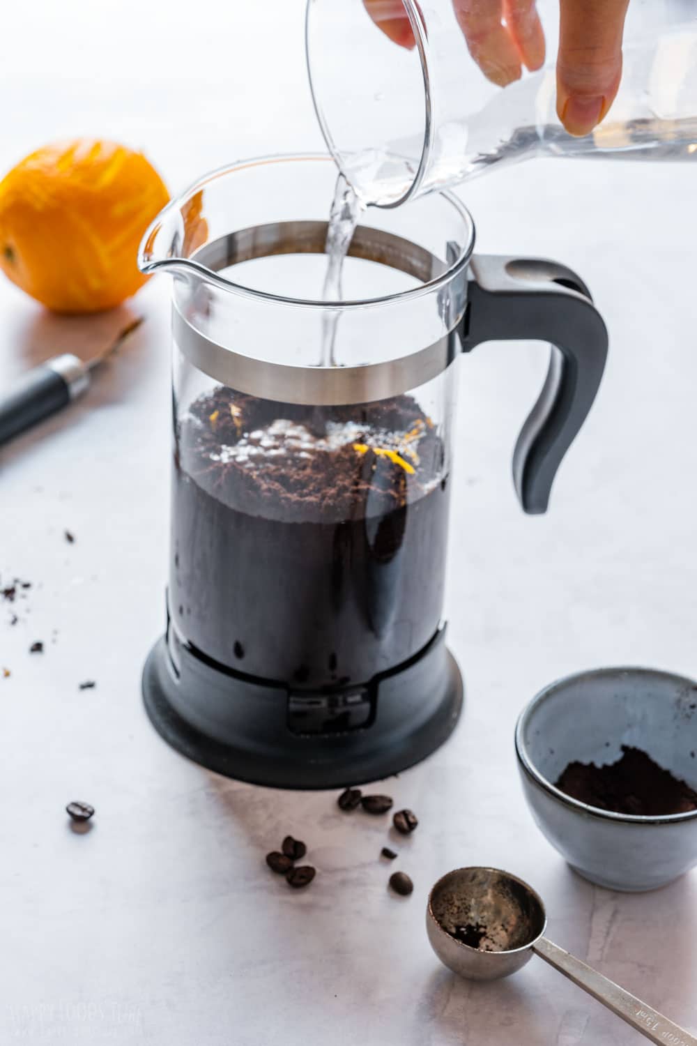 Pouring water to French press to brew cold coffee.